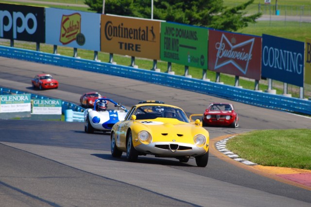 Joe Colasacco (#8), driving his 1963 Alfa Romeo TZ-1, leads Henry Gentry (#4) in a 1964 Ginetta G4 up through the esses.